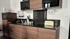 A modern kitchen with a microwave, coffee maker, and a toaster.