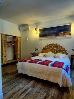 A bedroom with a bed, a wooden headboard, a nightstand, a wall-mounted lamp, a painting, and a wardrobe. - Mas La Fontaine de Pernes, les pieds dans la Sorgue, piscine, 12p, 6ch, 5sdb (Pernes-les-Fontaines)