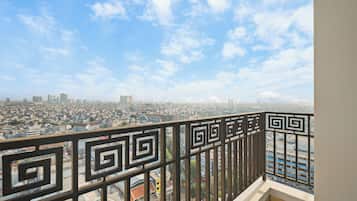 Un balcón con barandilla de metal que da a una vista panorámica de la ciudad.
