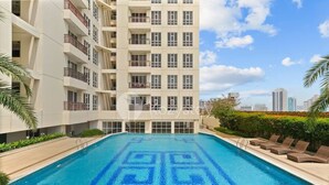 A modern apartment building with a swimming pool featuring a geometric pattern. - Seran by Kozystay  - Taman Sari (West Jakarta)