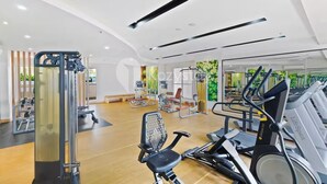 A modern gym with cardio machines, weight training equipment, and a mirrored wall. - Seran by Kozystay  - Taman Sari (West Jakarta)