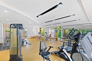 Ein modernes Fitnessstudio mit Cardiogeräten, Krafttrainingsgeräten und einer Spiegelwand.