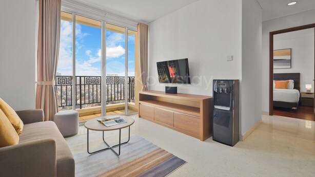 A modern living room with a sofa, a coffee table, a TV, and a refrigerator. - Seran by Kozystay  - Taman Sari (West Jakarta)