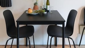 Un comedor con mesa, sillas y una obra de arte en la pared.