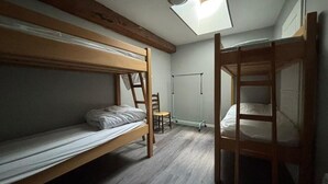 Un dormitorio con literas, tragaluz y radiador.