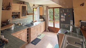 Una cocina con armarios de madera, salpicadero de azulejos y horno empotrado.