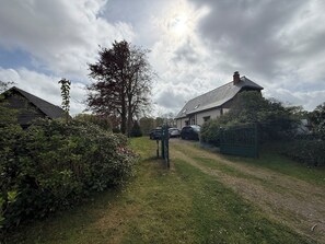 Ein ländliches Anwesen mit einem Haus, einem Auto und einem Tor.