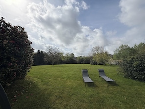 A grassy outdoor area with two lounge chairs and a hedge. - Les Buissons (st pierre le vieux)