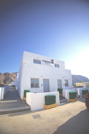 A white building with a sign reading 'TINAMARIS SELECTIONS'. - Tinamar Selection (Santorini)