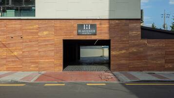 A hotel entrance with a sign reading 'H. AVENUE HOTEL' and a covered walkway leading inside.