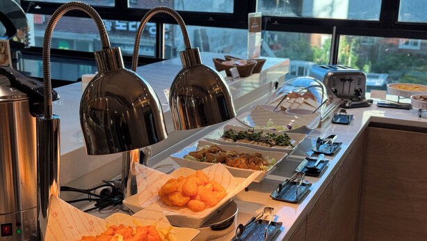 Ein reichhaltiges Buffet mit verschiedenen Speisen und einer Kaffeemaschine.