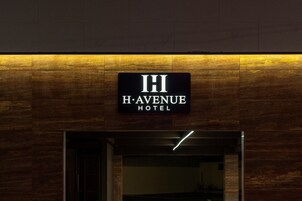 Un letrero del HOTEL HI HAVENUE, con un diseño moderno y fachada de madera.