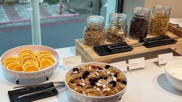 Un bufé de desayuno con diferentes alimentos y utensilios.