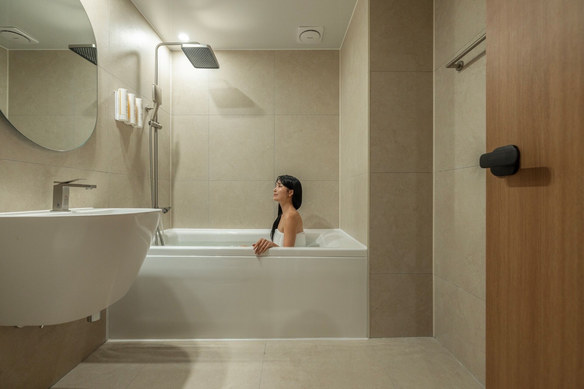 A bathroom with a freestanding bathtub, a sink, and a mirror.