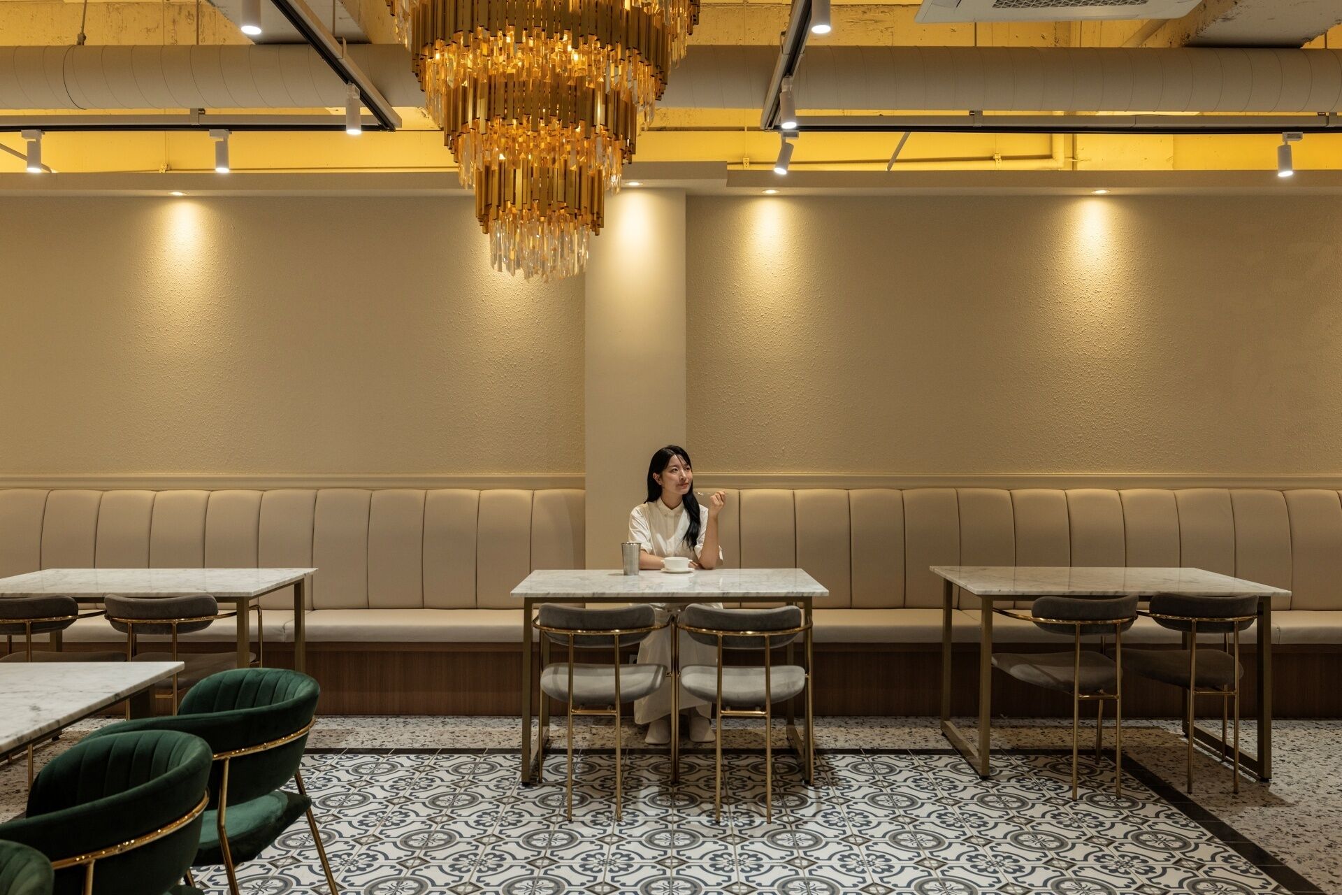A restaurant interior with a central seating area, booths, and a patterned floor.
