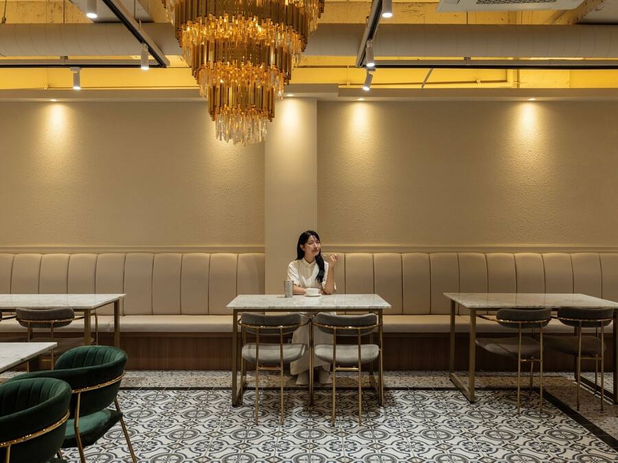 A restaurant interior with a central seating area, booths, and a patterned floor.