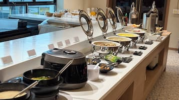 Montaje de bufé con diferentes alimentos y una máquina de café.