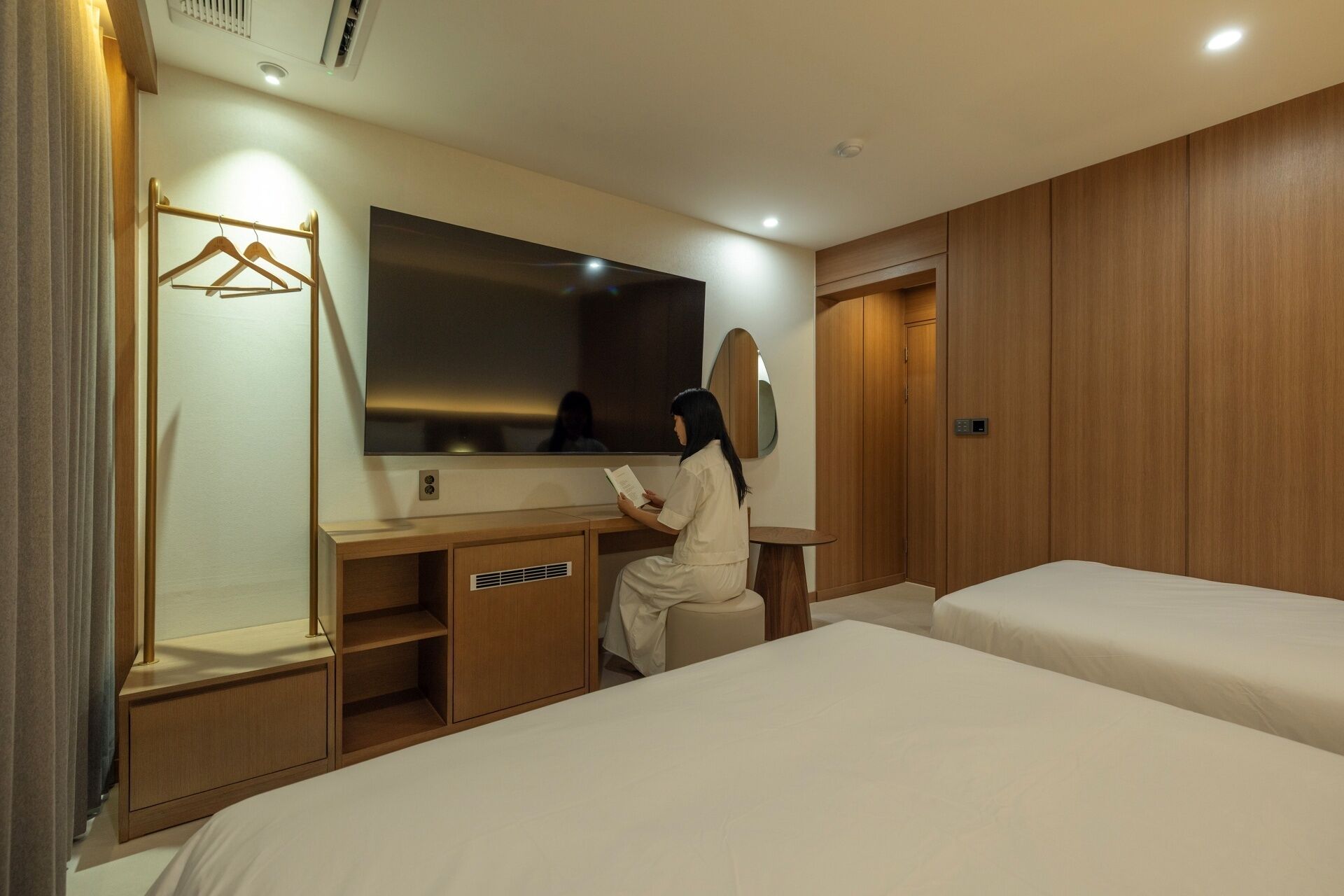 Una habitación de hotel con cama, escritorio, espejo y armario.