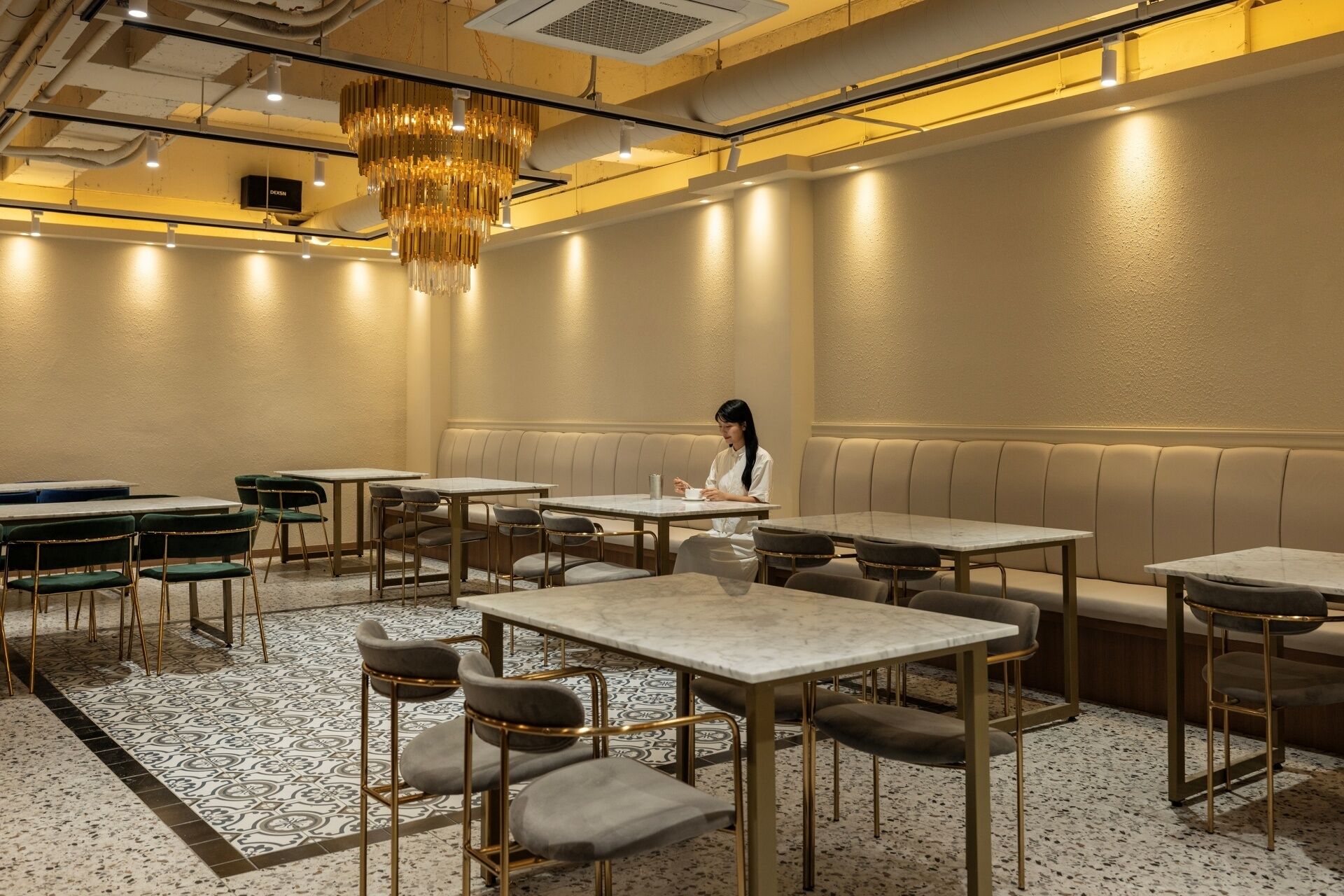 Interior de restaurante con cabinas, mesas y una araña.