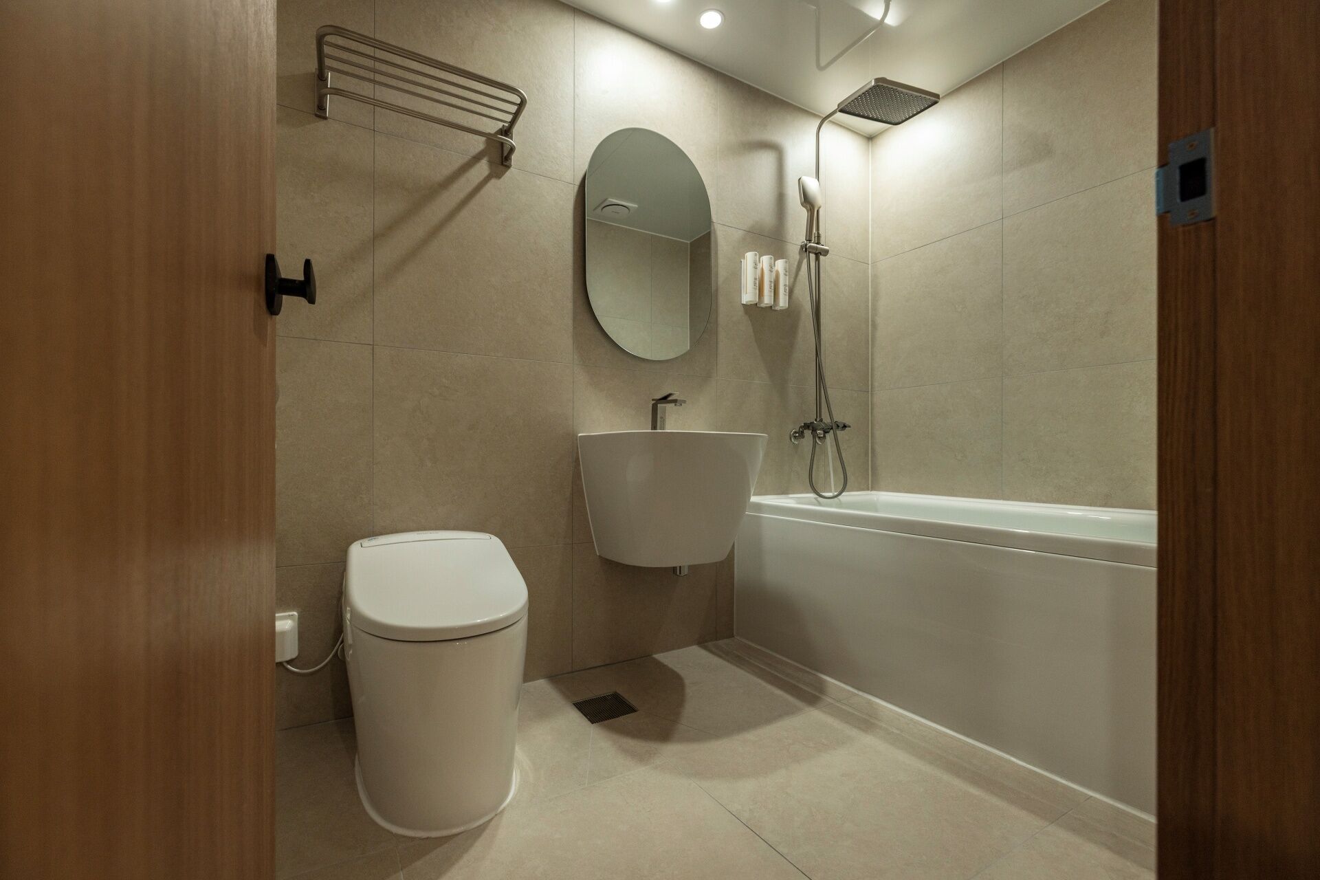 A modern bathroom with a toilet, sink, and bathtub.