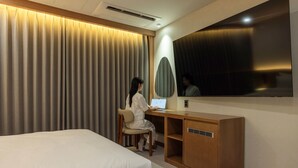 Ein Hotelzimmer mit einem Bett, einem Schreibtisch und einem Spiegel.