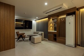 Una sala de estar moderna con un sofá, una mesa de centro y un televisor montado en la pared.