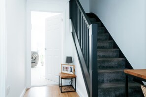 A staircase with a dark railing and a wooden table beside it.