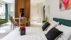 A modern hotel room with a bed, a dining area, and a living space. - Apartment in Porspoder Near Plage du Bourg (Warsaw)
