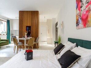 Ein modernes Hotelzimmer mit Bett, Essbereich und Wohnbereich.