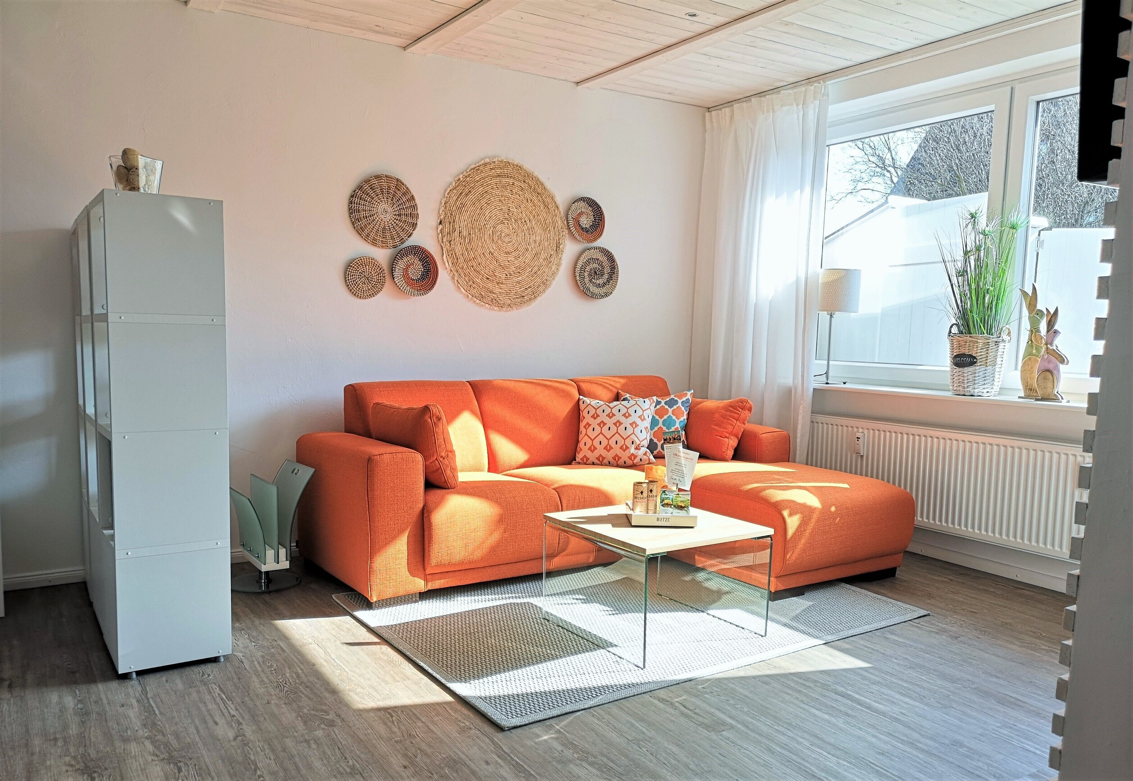 Ein Wohnzimmer mit einer Couch, einem Couchtisch und dekorativen Wandgestaltungen.