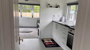 A modern kitchen with white cabinets, a black countertop, and a window.