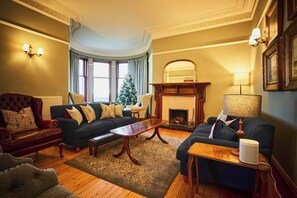 A traditional living room with a fireplace, two sofas, a coffee table, and a Christmas tree. - Kinclune House Luxury Estate Mansion, Angus Glens (Kirkton of Kingoldrum)