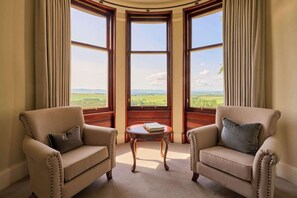 A room with two armchairs facing a bay window overlooking a landscape. - Kinclune House Luxury Estate Mansion, Angus Glens (Kirkton of Kingoldrum)