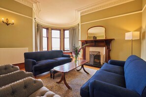 A living room with two sofas, a fireplace, and a large window. - Kinclune House & Annex Luxury Mansion, Angus Glens (Kirkton of Kingoldrum)