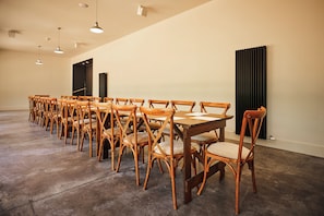 A conference room with wooden chairs and tables, a black door, and a radiator on the wall. - Kinclune House & Annex Luxury Mansion, Angus Glens (Kirkton of Kingoldrum)