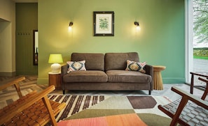 A living room with a sofa, two pillows, a lamp, and a framed picture on the wall. - Stylish Barn Conversion, Woodland Views, Angus (Kirkton of Kingoldrum)
