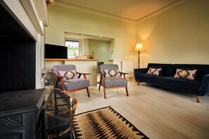 A living room with a sofa, two armchairs, a television, and a fireplace. - Peaceful Farmhouse, Kinclune Estate, Angus Glens (Kirkton of Kingoldrum)