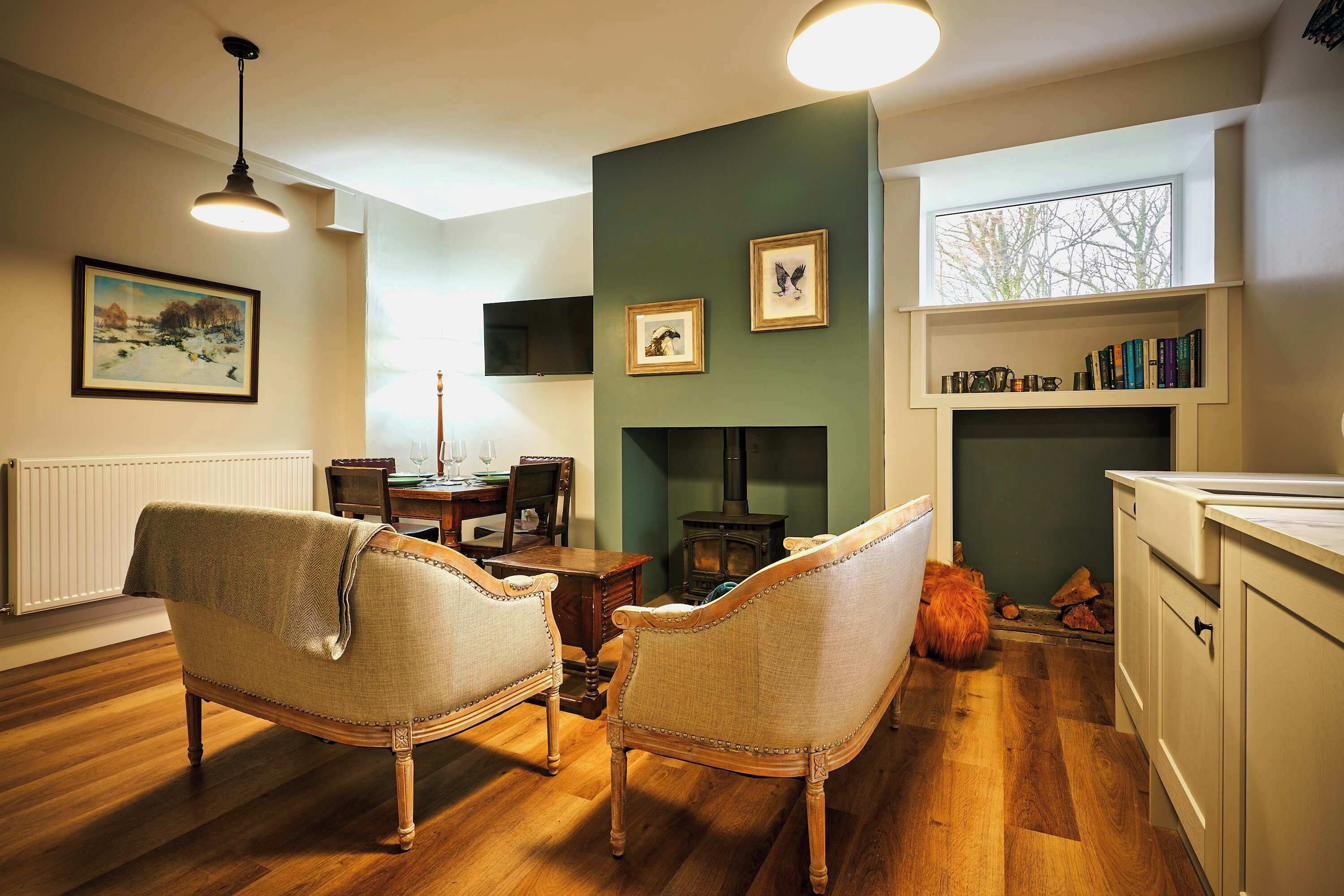 A cozy living room with a fireplace, wooden furniture, and a bookshelf.