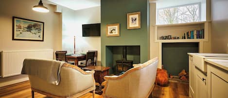 A cozy living room with a fireplace, wooden furniture, and a bookshelf.