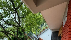 Una escalera con macetas, barandilla metálica y pared de ladrillo.