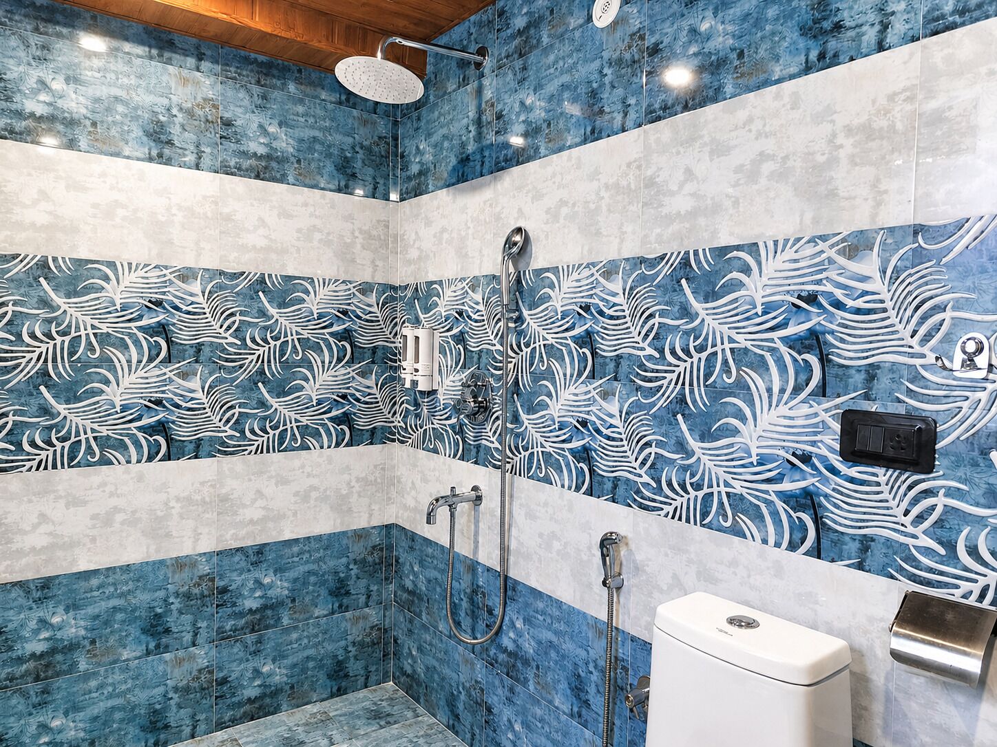 A bathroom with a shower, toilet, and a towel dispenser.