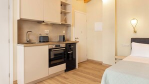 A compact kitchen with a built-in oven, a dishwasher, and a coffee machine. - Studio Tepes - Velis Samos Sea View Balcony Suite (Kokkari)