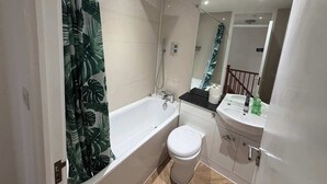 Ein modernes Badezimmer mit einer Badewanne, Toilette und Waschbecken.