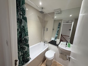 A bathroom with a bathtub, toilet, and sink. - 2BDR House with Private Garden and Parking (Greater London)