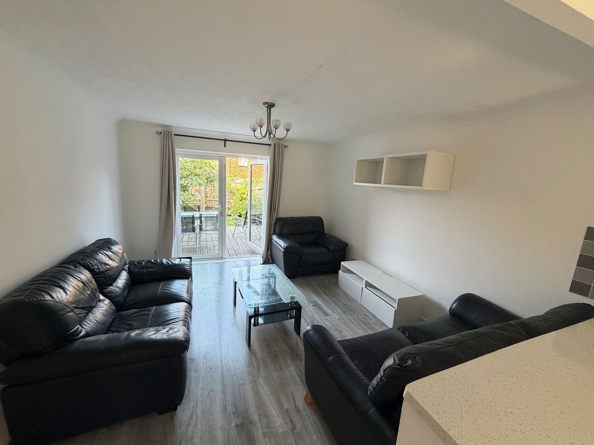 A modern living room with a sofa set, a coffee table, and a dining area.
