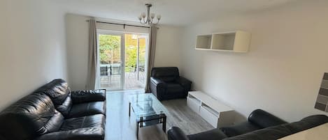 A modern living room with a sofa set, a coffee table, and a dining area.