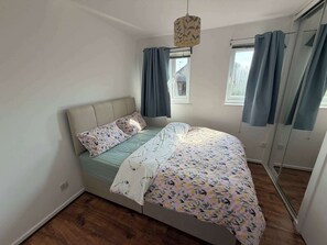 A bedroom with a bed, a window, and a door. - 2BDR House with Private Garden and Parking (Greater London)