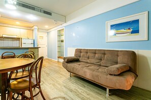 Ein modernes Wohnzimmer mit einem braunen Sofa, einem Holzespeisetisch und Stühlen.