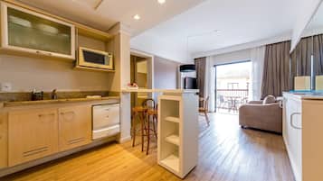 A modern kitchen with wooden cabinets, a microwave, and a dining area with a sofa and chairs.