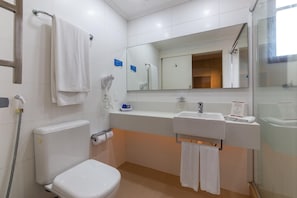 Un baño con inodoro, lavabo y ducha.